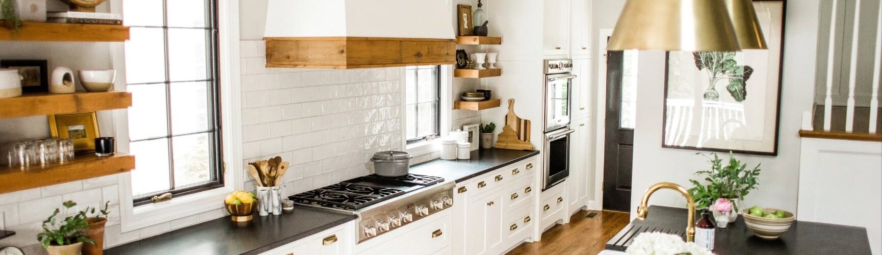 Galley style kitchen with white cabinets and black countertops.